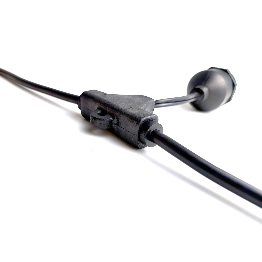 Close-up of a connector component used in integrated head molding process lights with black cables on white background