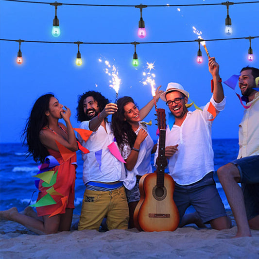 Friends enjoying a beach party with colorful Outdoor String Lights and sparklers at sunset