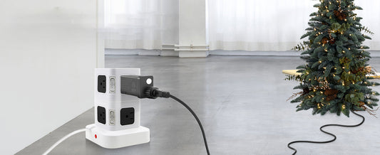 White power strip with plug connected to the best transformer for LED string lights beside a decorated Christmas tree
