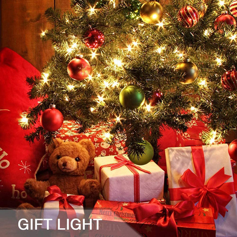 Battery String Lights glowing warmly on a decorated Christmas tree with presents and teddy bear underneath