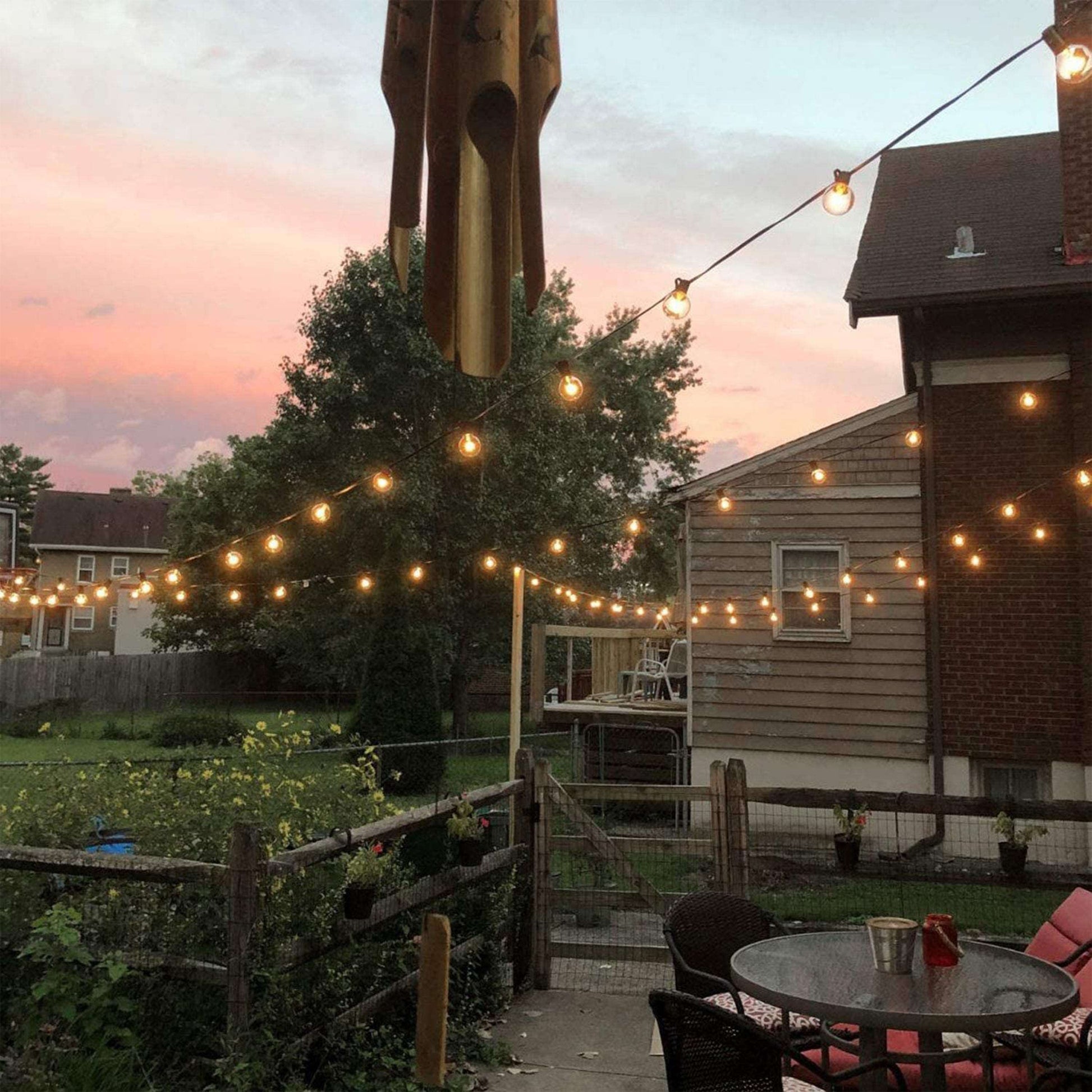 Outdoor decorative lights strung across backyard patio creating warm ambient lighting at sunset