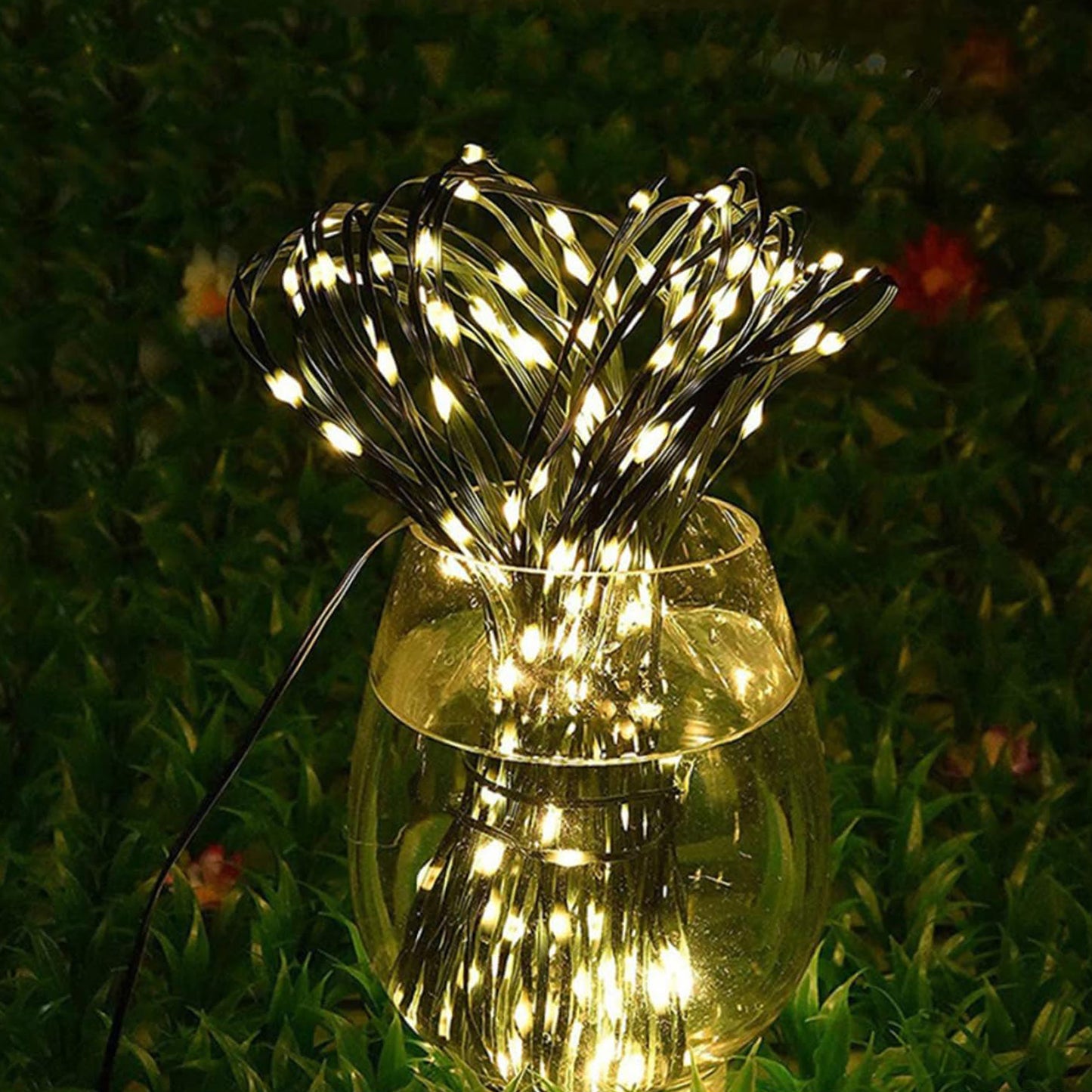 Ningbo Fuaisi Festoon String Lights in a clear vase surrounded by greenery for outdoor ambiance