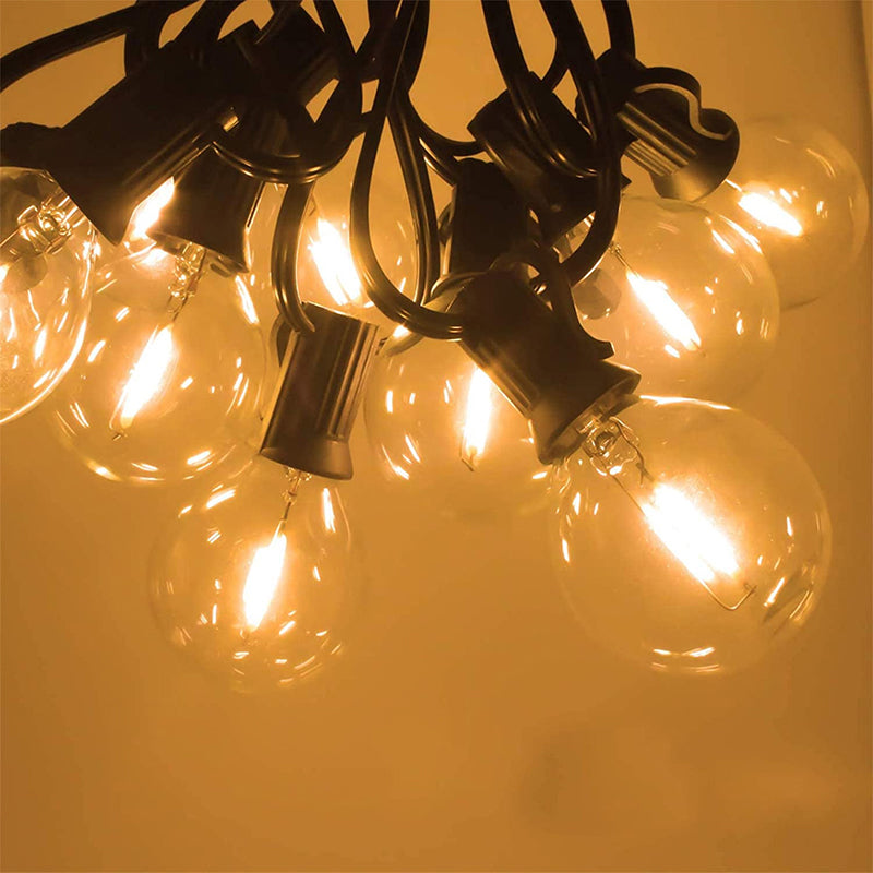 Warm glowing G40 LED Bulb string lights with clear round bulbs and black sockets