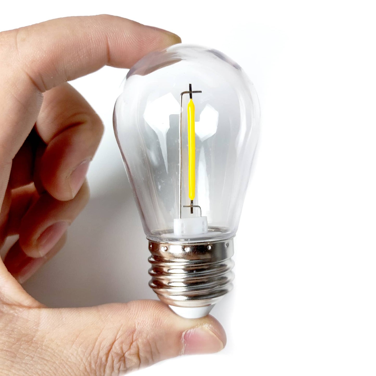 Hand holding a small clear LED bulb designed for garden lights outdoor by Ningbo Fuaisi Electric Appliance