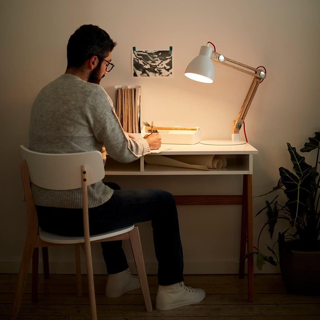 Man writing at desk illuminated by a white lamp with GU10 led bulb providing warm light