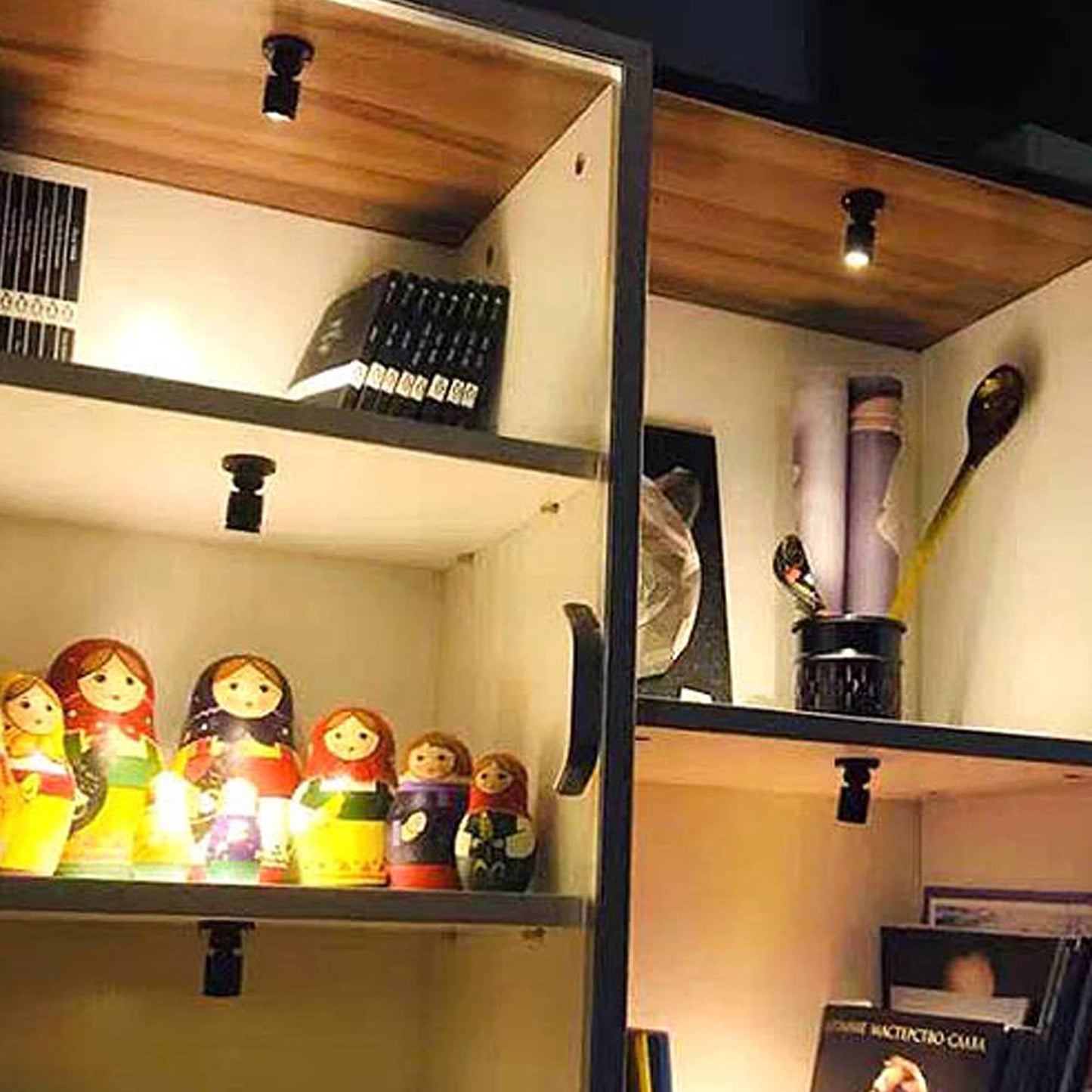 LED cabinet lights installed inside wooden shelves illuminating decorative items and books