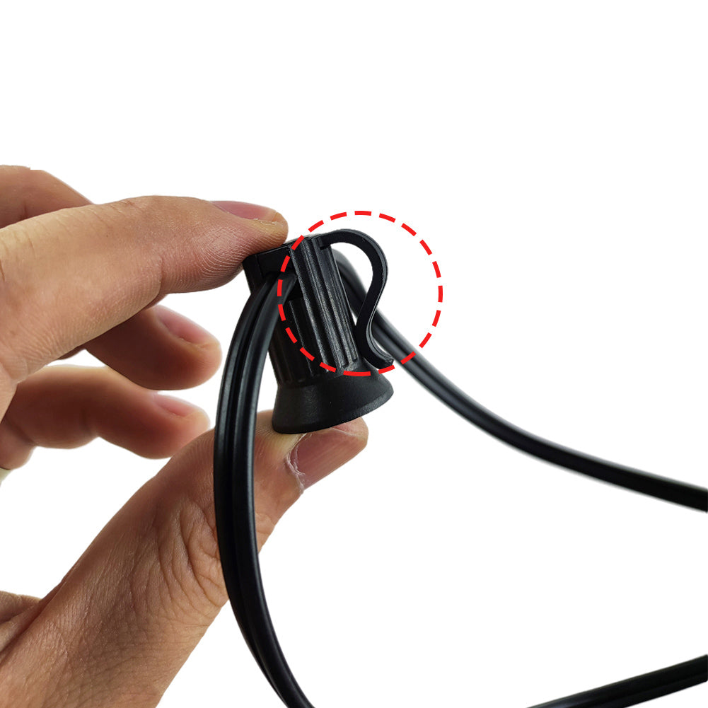 Close-up of hand holding black cable connector for solar led outdoor lighting setup