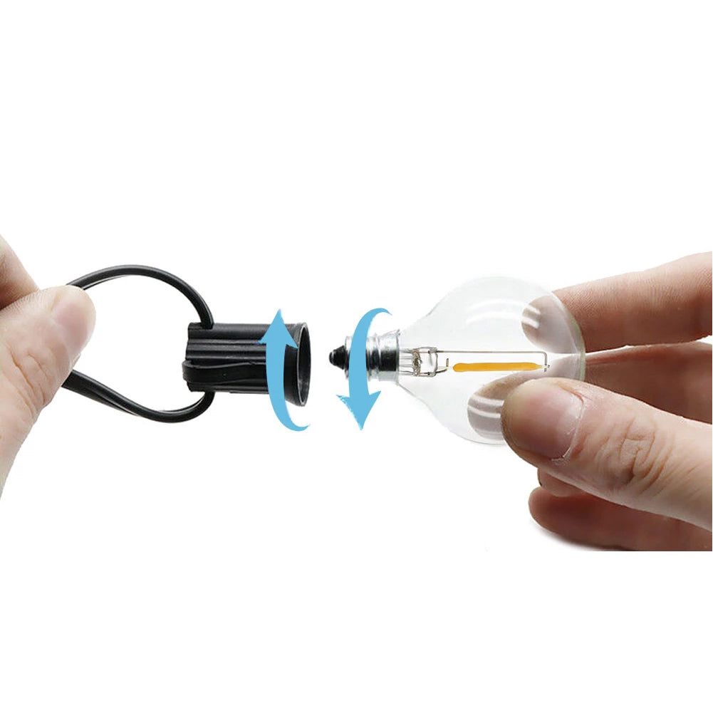 Hands installing a clear LED bulb into black solar led outdoor lighting fixture showing connection process