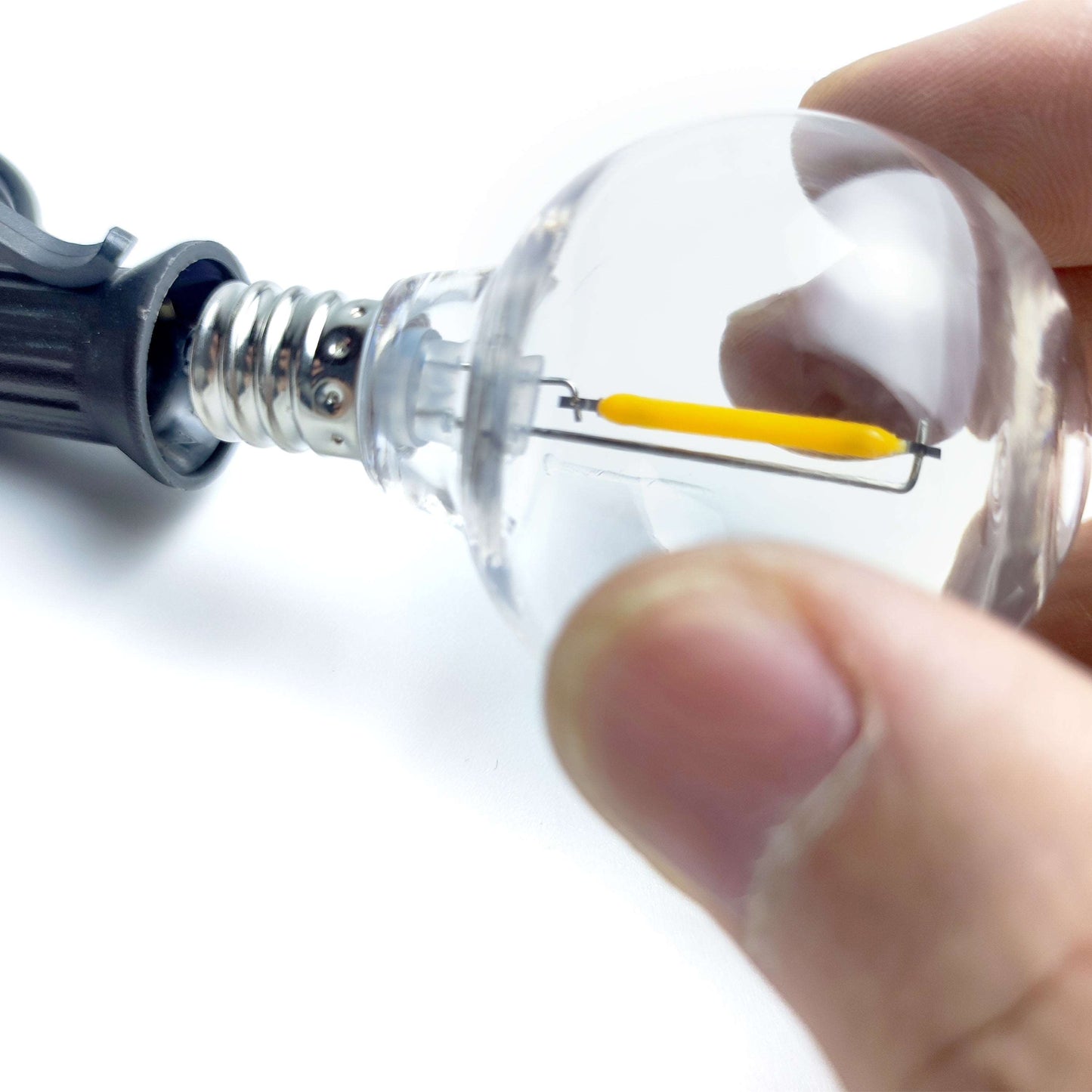 Close-up of hand holding a clear bulb for outdoor solar lights from Ningbo Fuaisi Electric Appliance