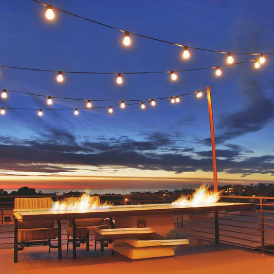 Outdoor patio at sunset featuring the best patio string light bulbs hanging above a fire pit table