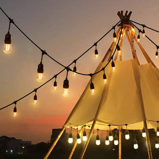 Outdoor string lights installation guide featuring warm glowing bulbs strung around a teepee at sunset