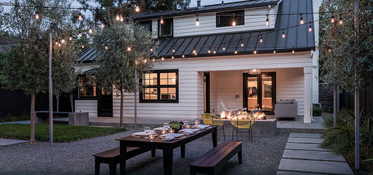 Cozy backyard patio setup with string lights fire pit and dining table showcasing outdoor garden decoration tips
