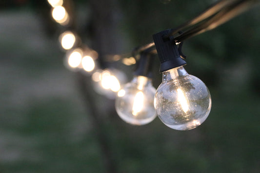 Close up of glowing outdoor string lights showing how to calculate max run string lights for decoration
