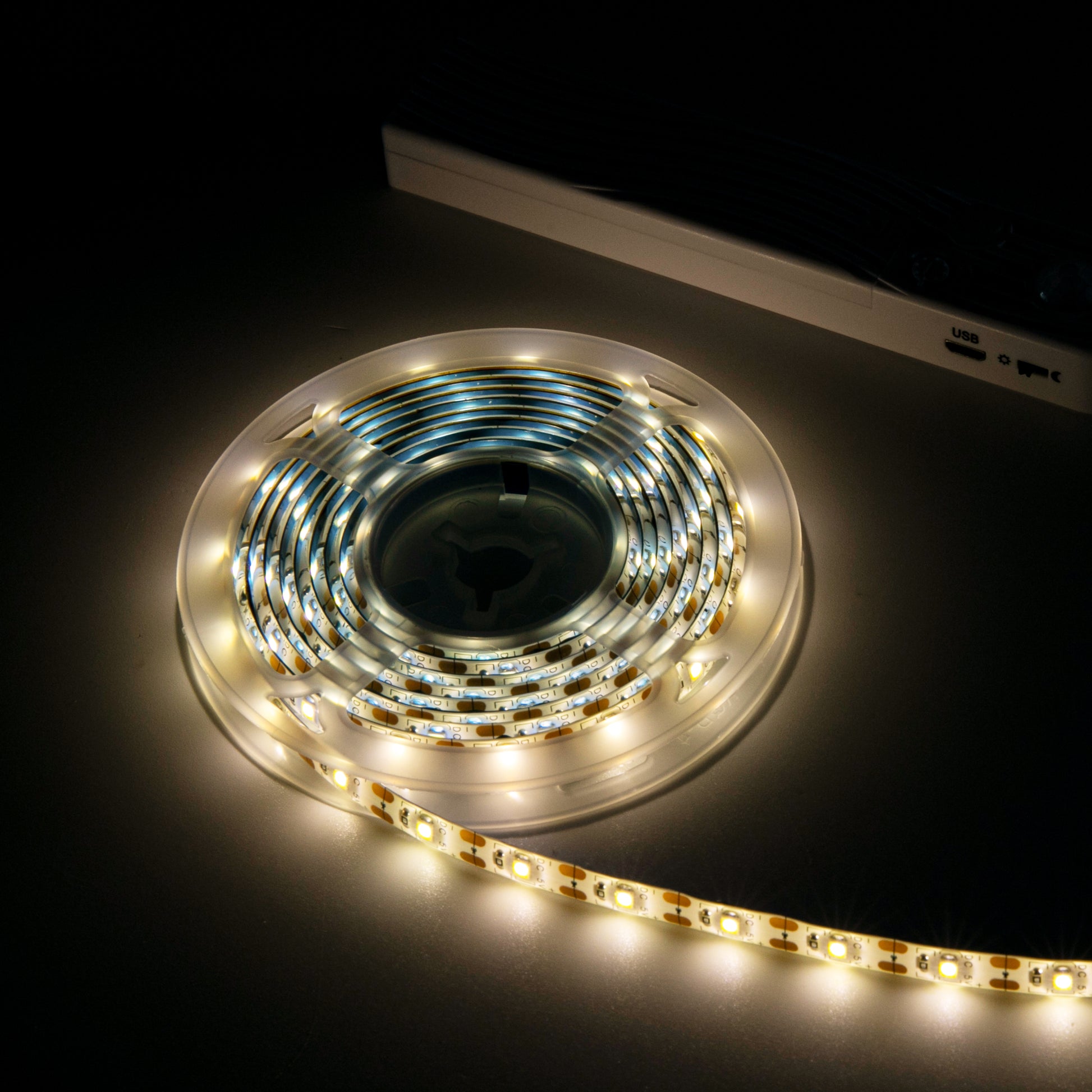 Battery LED Strip lights glowing warm white on spool by Ningbo Fuaisi Electric Appliance Co Ltd