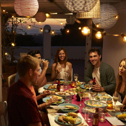 Outdoor dining area lit by Ningbo Fuaisi camping string lights with friends enjoying a meal together