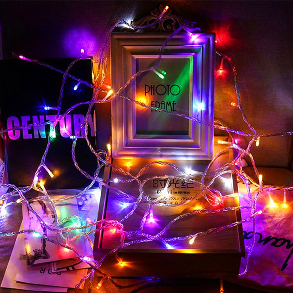 Colorful LED Christmas Lights wrapped around a photo frame and books for festive decoration