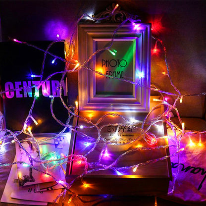 Colorful LED Christmas Lights wrapped around a photo frame and books for festive decoration