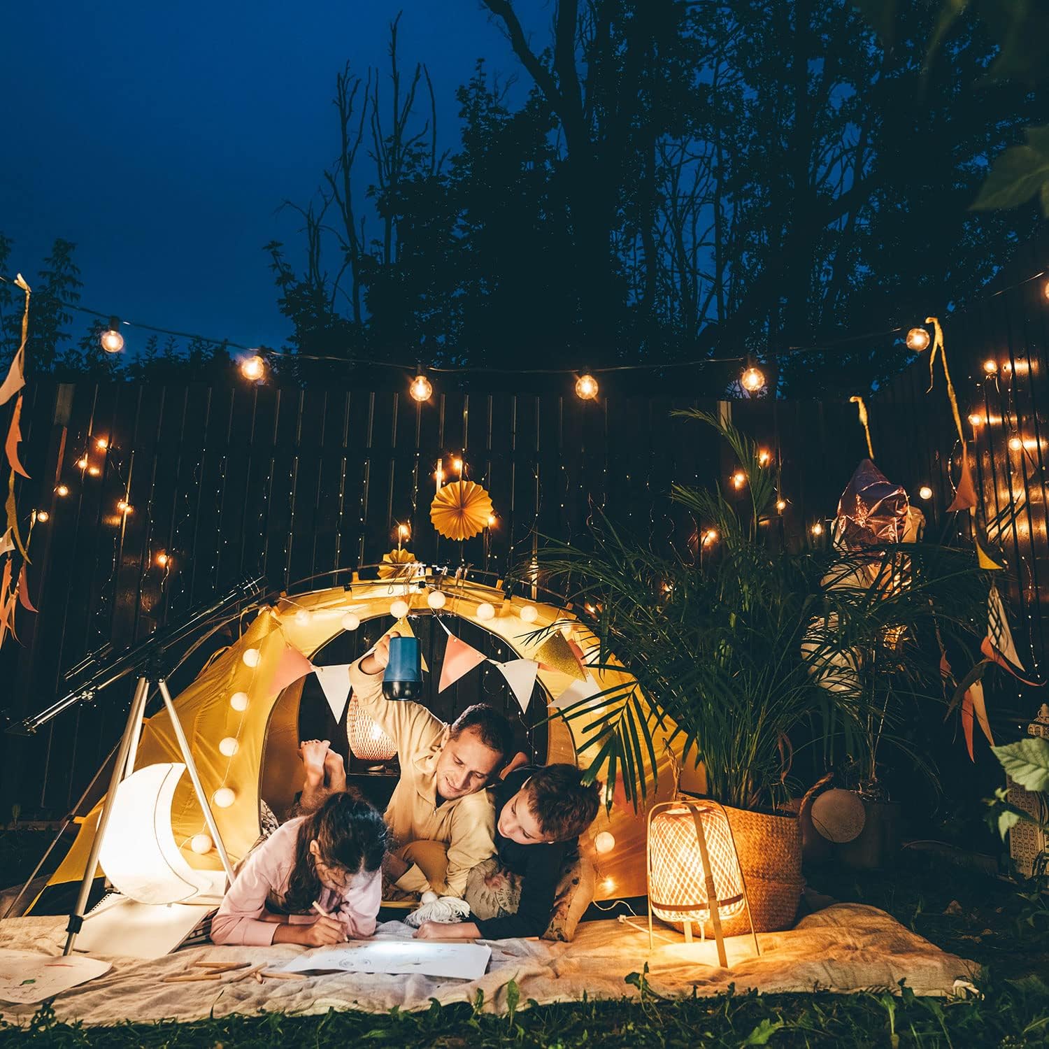 Cozy outdoor scene with LED Solar Fairy String Lights illuminating a tent and people enjoying the evening